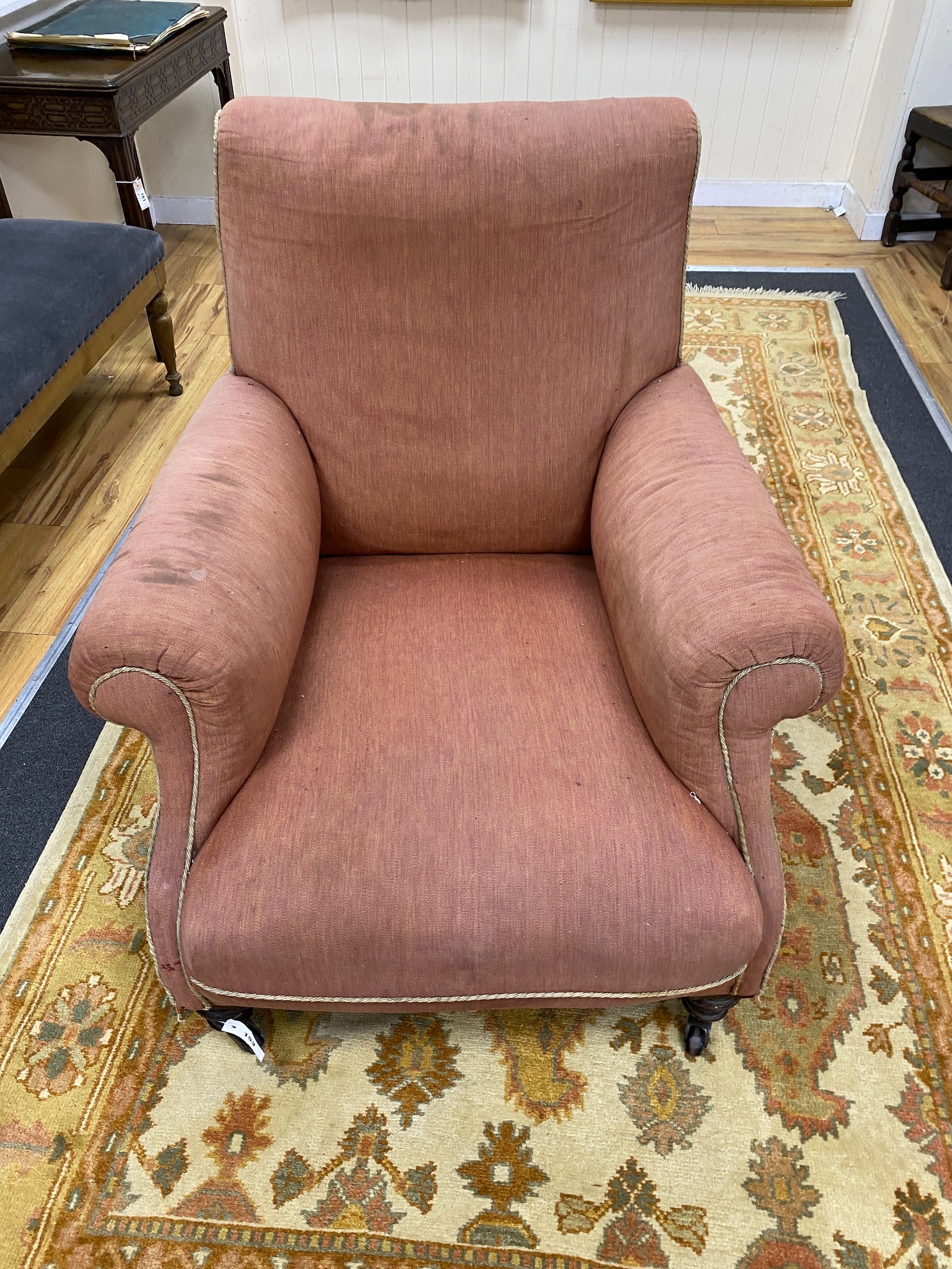 A Victorian mahogany armchair, upholstered faded red fabric, width 90cm, depth 102cm, height 96cm